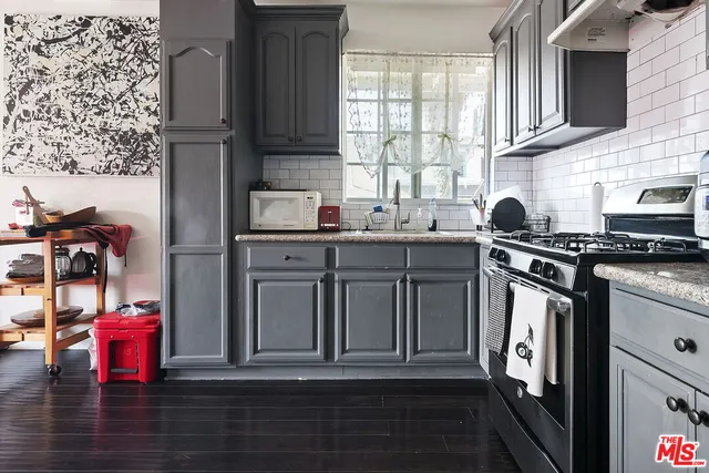 a kitchen with stainless steel appliances granite countertop a stove a sink and a microwave