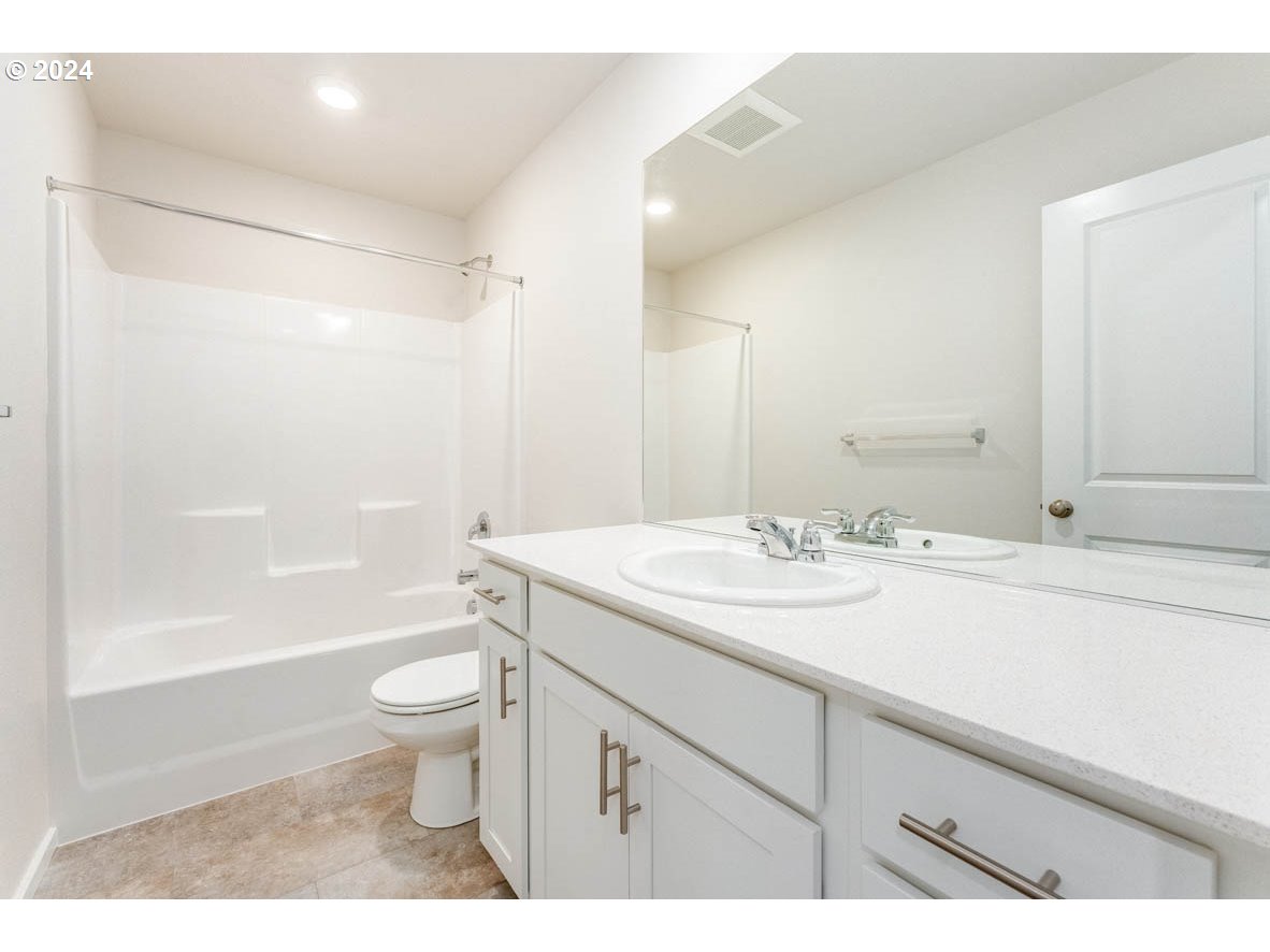 2654 U Street Springfield, OR 97477 - Photo 19 of 27 a bathroom with a sink a toilet and a large mirror