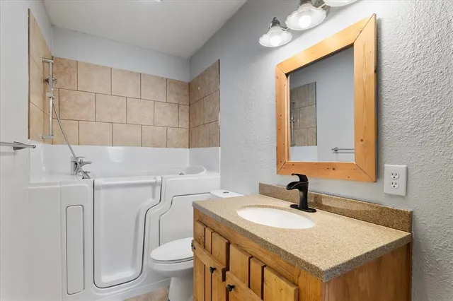 a bathroom with a sink toilet and mirror