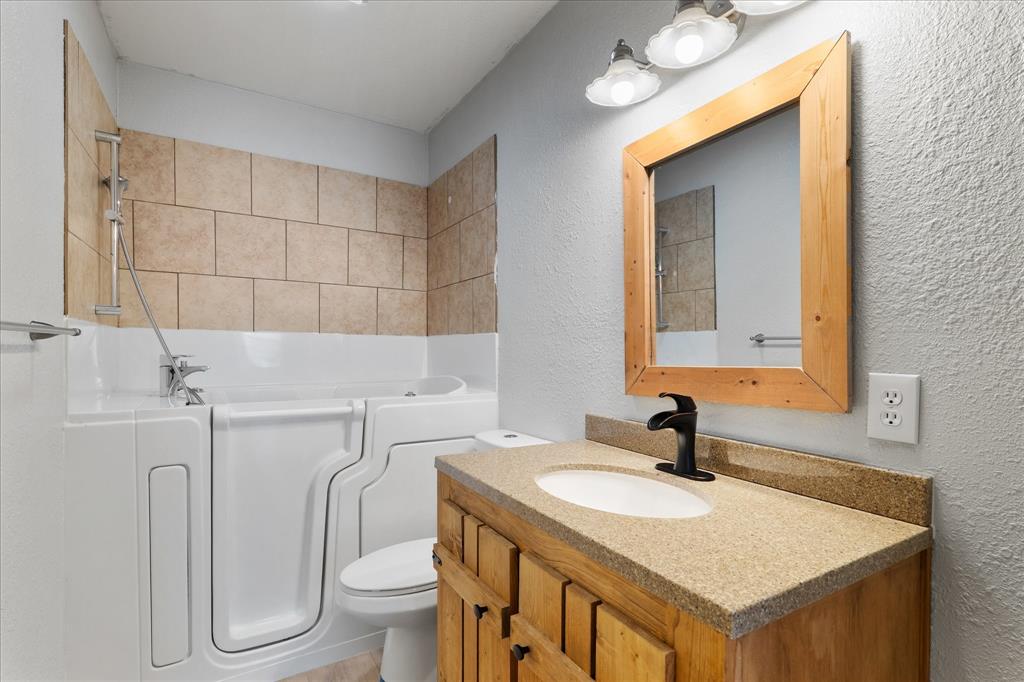 3300 Airport Road Tioga, TX 76271 - Photo 11 of 37 a bathroom with a sink toilet and mirror