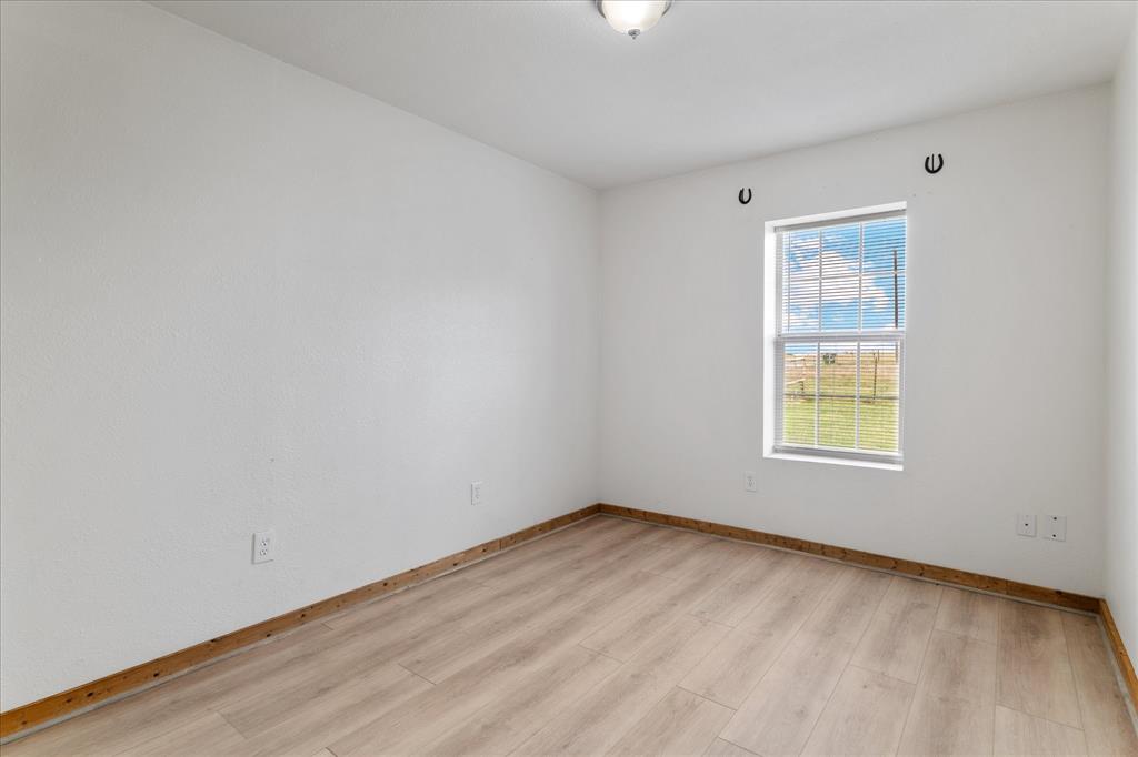 3300 Airport Road Tioga, TX 76271 - Photo 13 of 37 a view of an empty room with wooden floor and a window