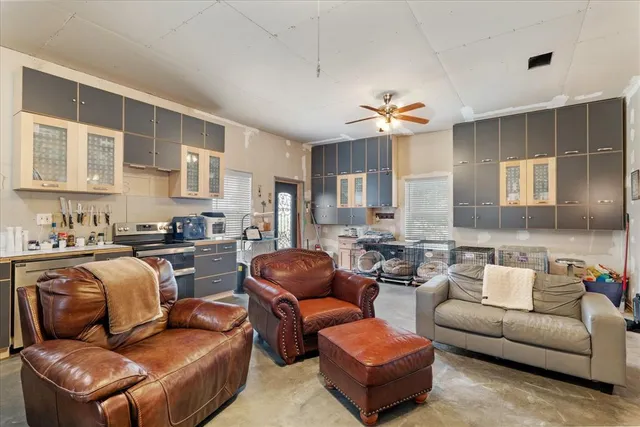 a living room with furniture kitchen view and a chandelier