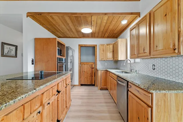 a kitchen with stainless steel appliances granite countertop a sink and cabinets