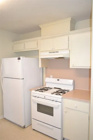 a white stove top oven sitting inside of a kitchen