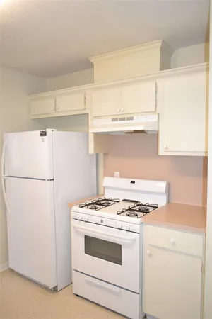 a white stove top oven sitting inside of a kitchen