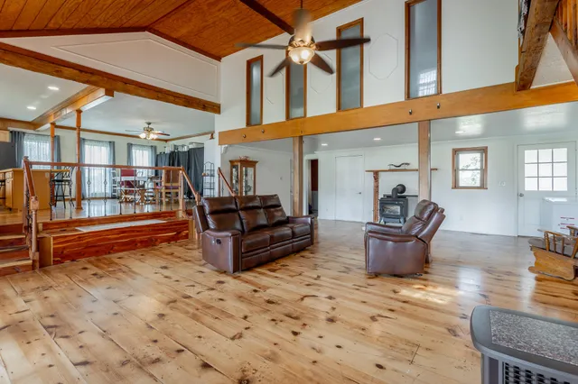 a living room with furniture a wooden floor and a large window
