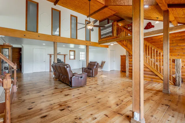 a kitchen with stainless steel appliances granite countertop a refrigerator a sink dishwasher a dining table and chairs with wooden floor