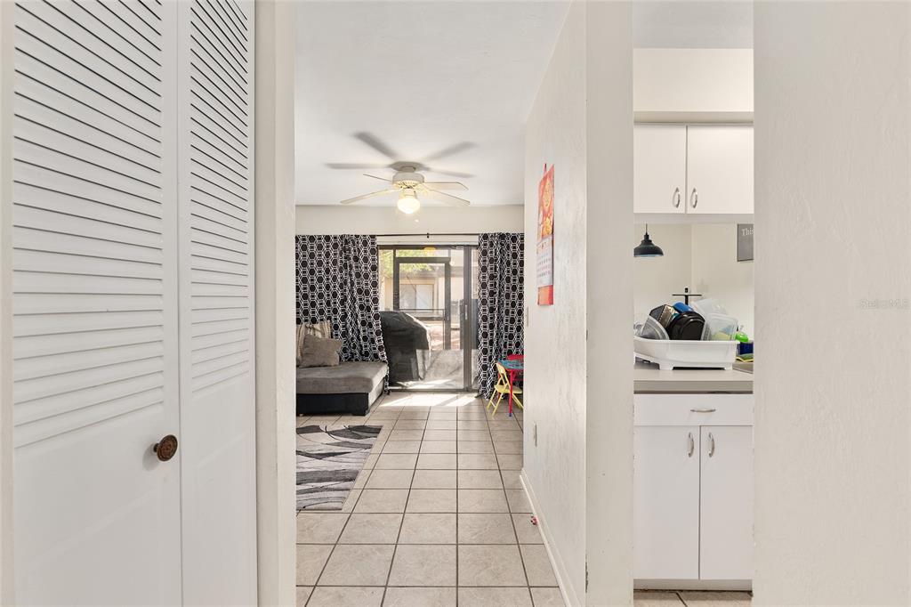 2735 Southwest 35th Place, Unit 801 Gainesville, FL 32608 - Photo 3 of 35 a hallway with a stove a mirror and a fan