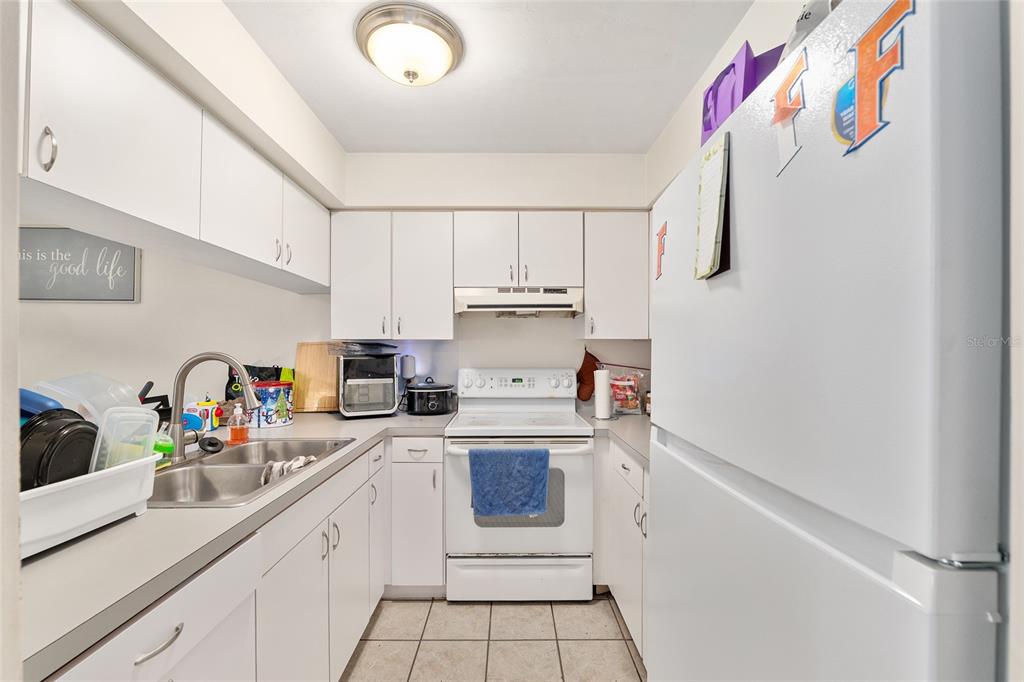 2735 Southwest 35th Place, Unit 801 Gainesville, FL 32608 - Photo 7 of 35 a kitchen with white cabinets and white appliances