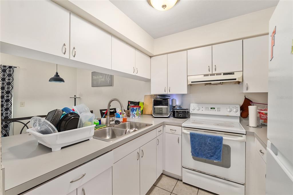 2735 Southwest 35th Place, Unit 801 Gainesville, FL 32608 - Photo 8 of 35 a kitchen with cabinets a sink and white appliances