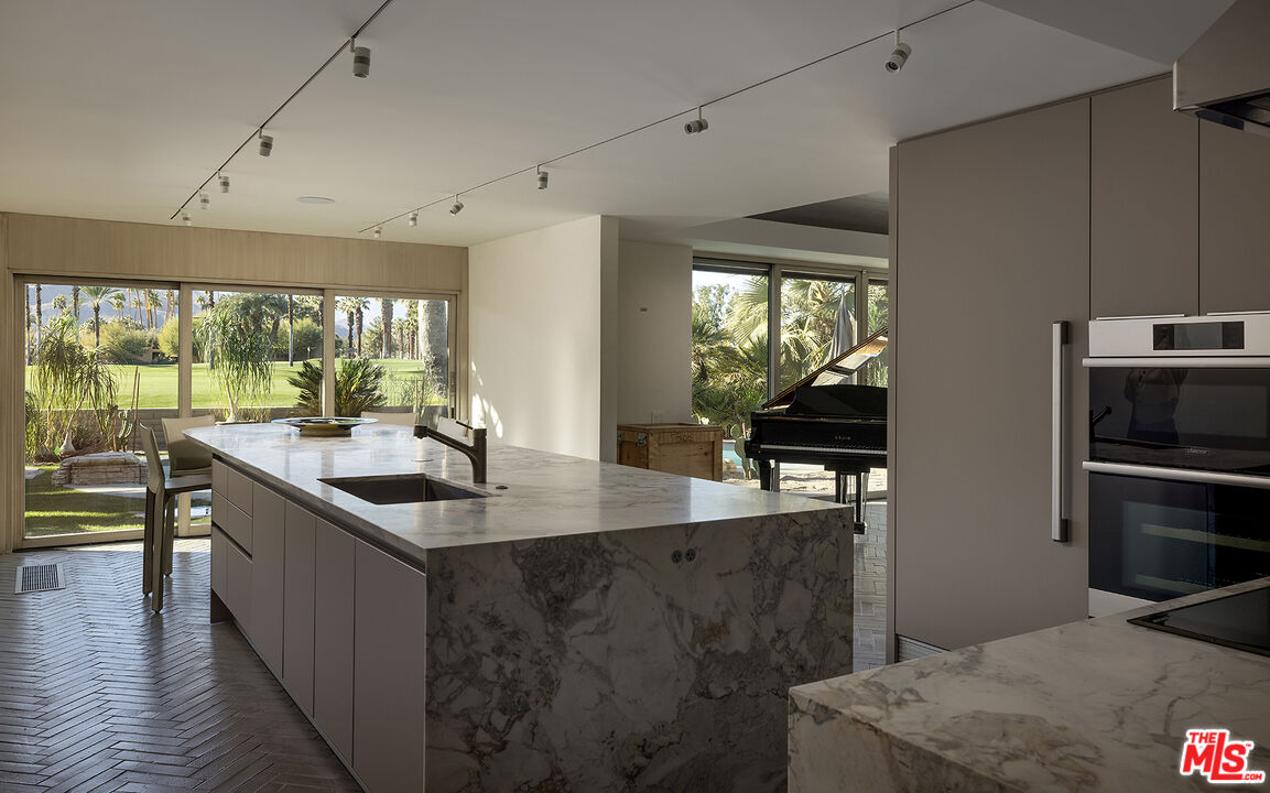 40281 Sand Dune Road Rancho Mirage, CA 92270 - Photo 16 of 39 a kitchen with stainless steel appliances granite countertop a sink a stove and a refrigerator