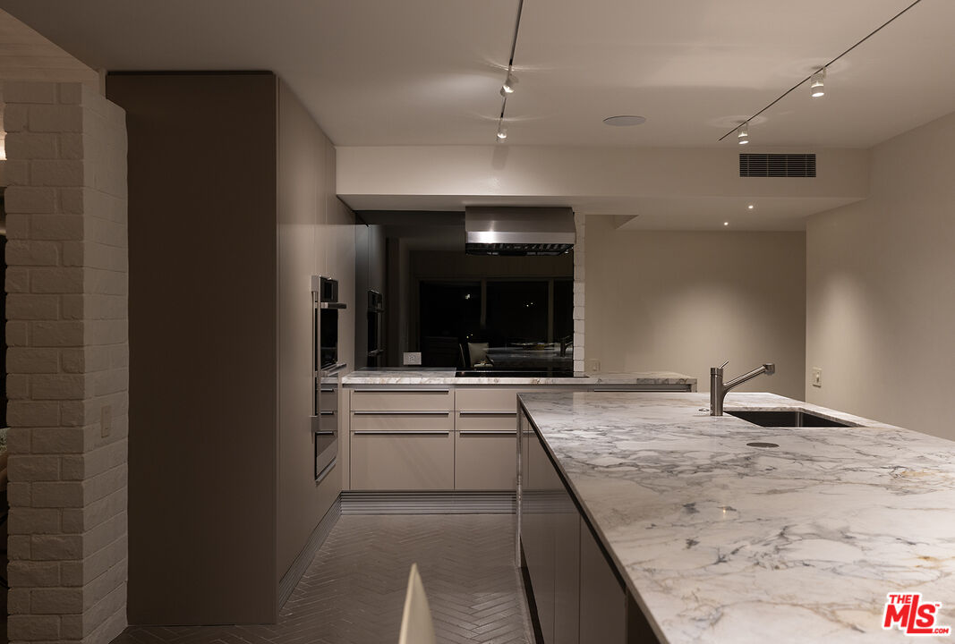 40281 Sand Dune Road Rancho Mirage, CA 92270 - Photo 18 of 39 a large kitchen with kitchen island a sink stainless steel appliances and a counter top space