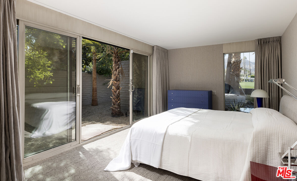 40281 Sand Dune Road Rancho Mirage, CA 92270 - Photo 26 of 39 a bedroom with a bed and glass door