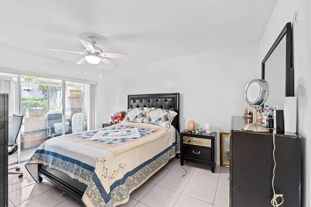 a bedroom with a bed a chandelier and dresser