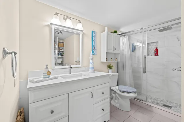 a bathroom with a granite countertop sink toilet and shower