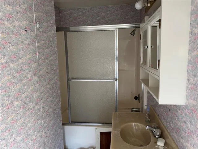 a bathroom with a granite countertop bathtub shower sink and toilet