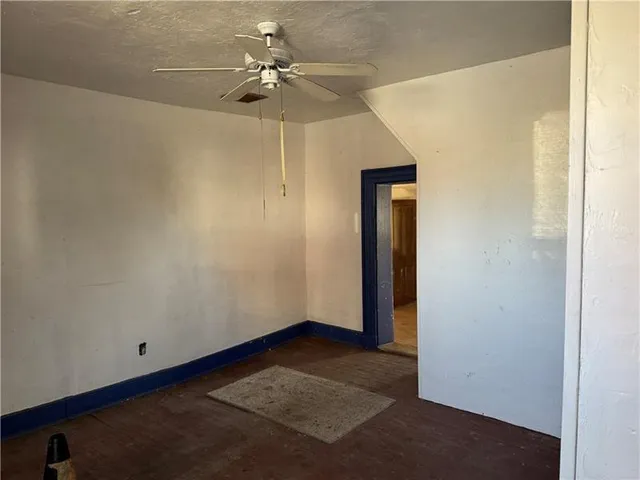 an empty room with a ceiling fan and a fan