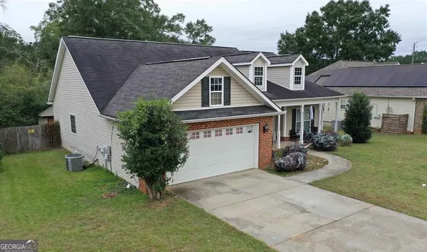 a view of a house with a yard and sitting area