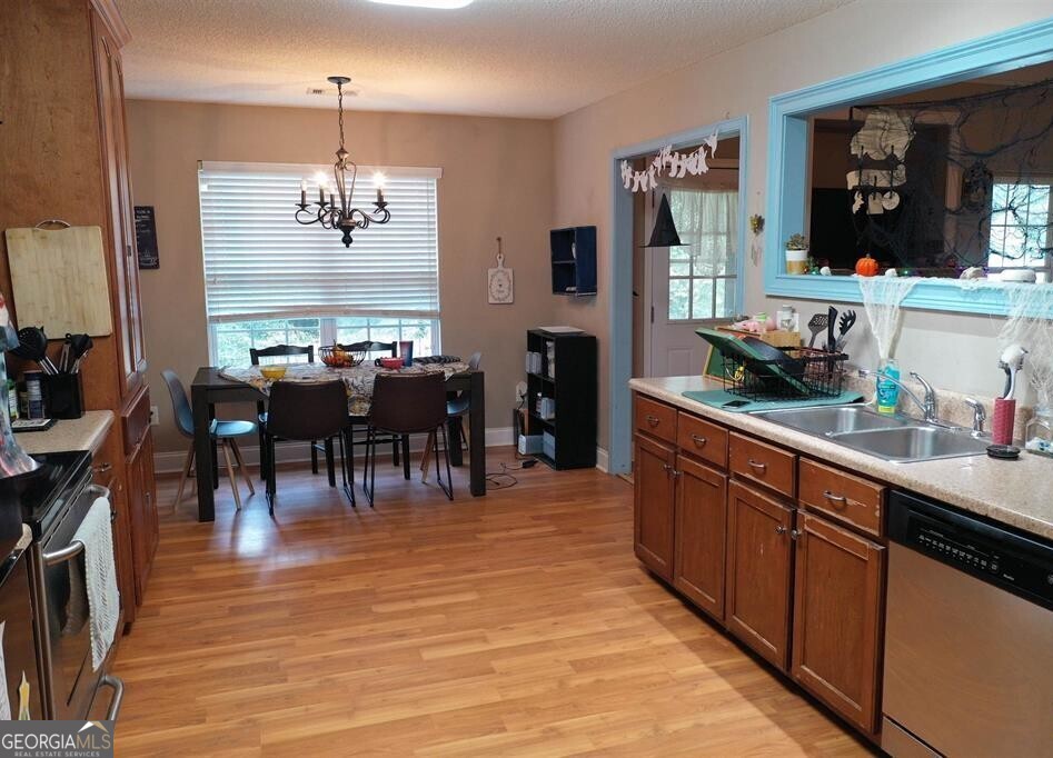 201 Boulder Creek Road Kathleen, GA 31047 - Photo 7 of 21 a large kitchen with stainless steel appliances kitchen island granite countertop a table chairs and a chandelier
