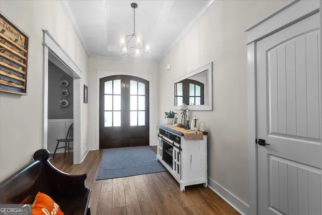 a living room with furniture kitchen view and a wooden floor