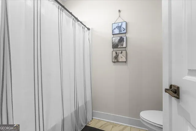 a kitchen with stainless steel appliances kitchen island granite countertop a table chairs stove and wooden floor