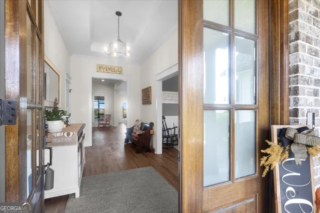 a living room with furniture kitchen view and a wooden floor