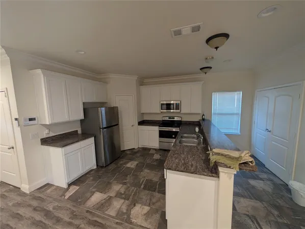 a kitchen with a refrigerator a stove top oven and a sink