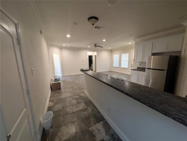 a large kitchen with a large counter top appliances and cabinets