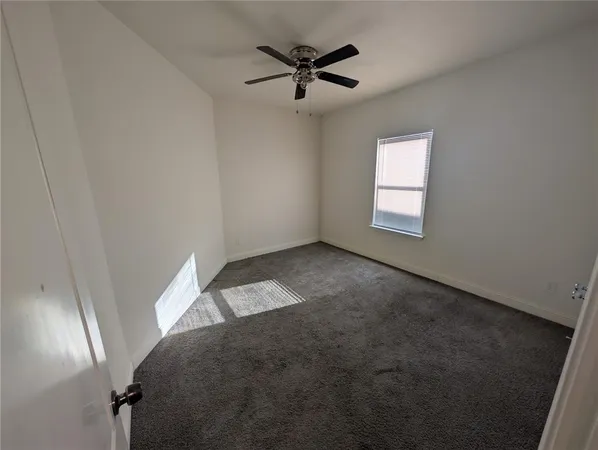 a view of a livingroom with a ceiling fan and window