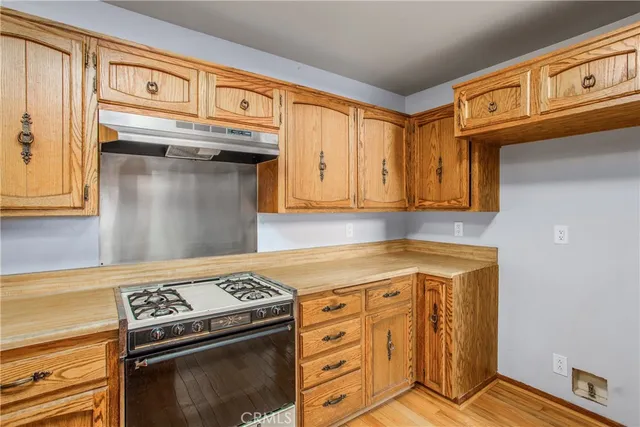 a kitchen with a stove a sink and a cabinets