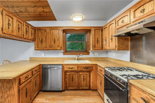 a kitchen with stainless steel appliances granite countertop a sink stove and cabinets