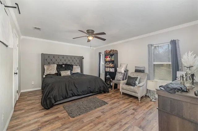 a spacious bedroom with a bed and a flat screen tv