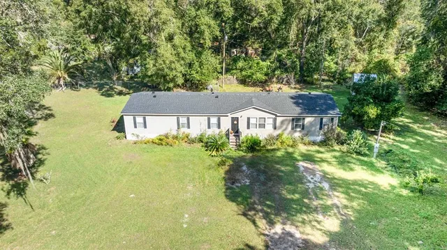 an aerial view of a house with yard and outdoor seating