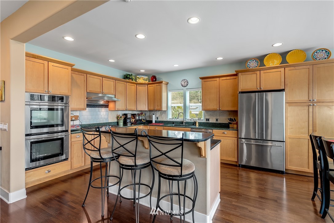 5615 Northeast 10th Street Renton, WA 98059 - Photo 8 of 35 a kitchen with a table chairs refrigerator and microwave