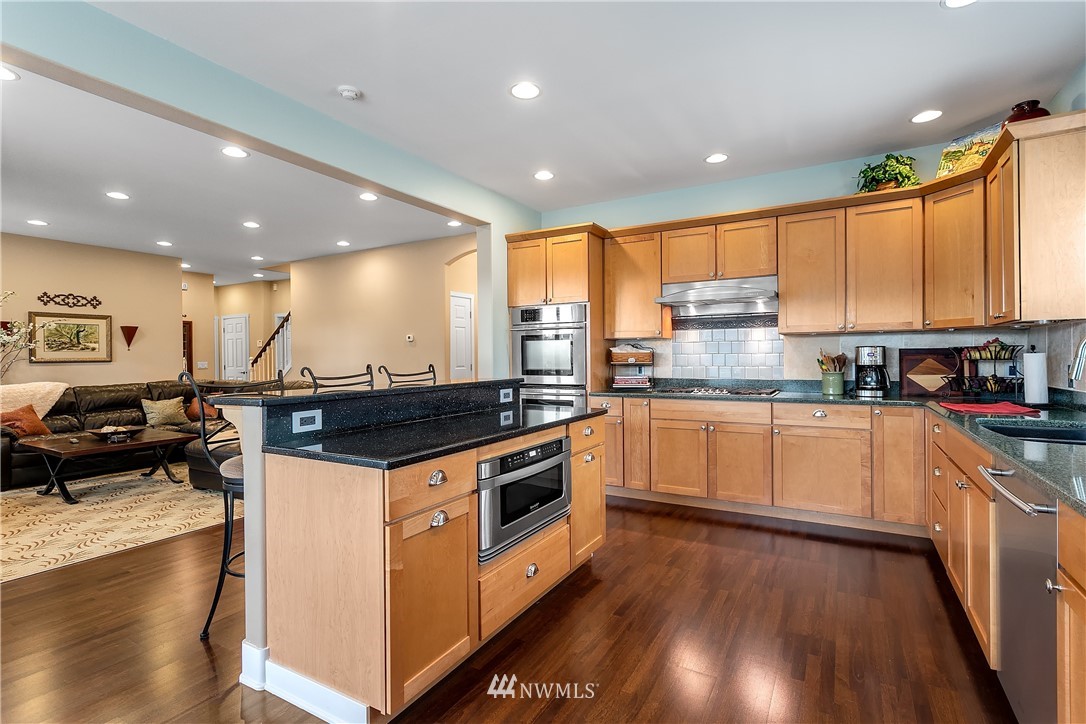 5615 Northeast 10th Street Renton, WA 98059 - Photo 10 of 35 a kitchen with stainless steel appliances granite countertop a stove a sink and a refrigerator