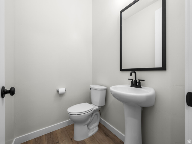 2786 West Hancock Street, Unit 198 Mapleton, UT 84664 - Photo 21 of 33 Pedestal sink with matte black faucet, framed mirror, and wood-finish flooring