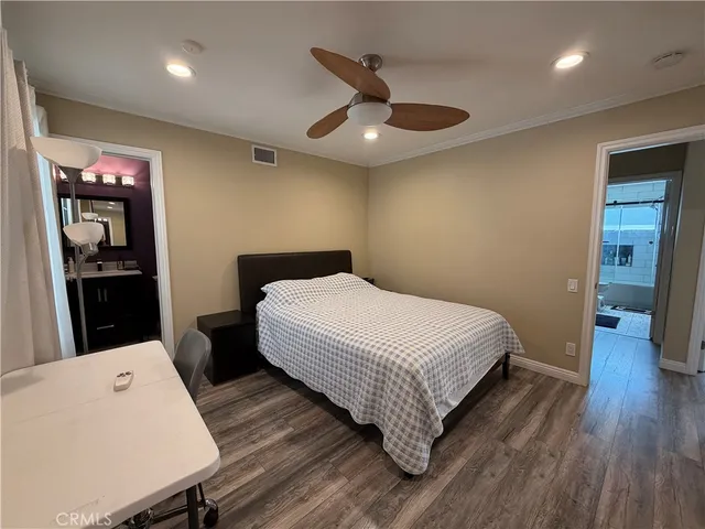 a bedroom with a bed and a wooden floor