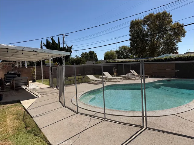 a view of a patio with a table chairs potted plants with wooden fence