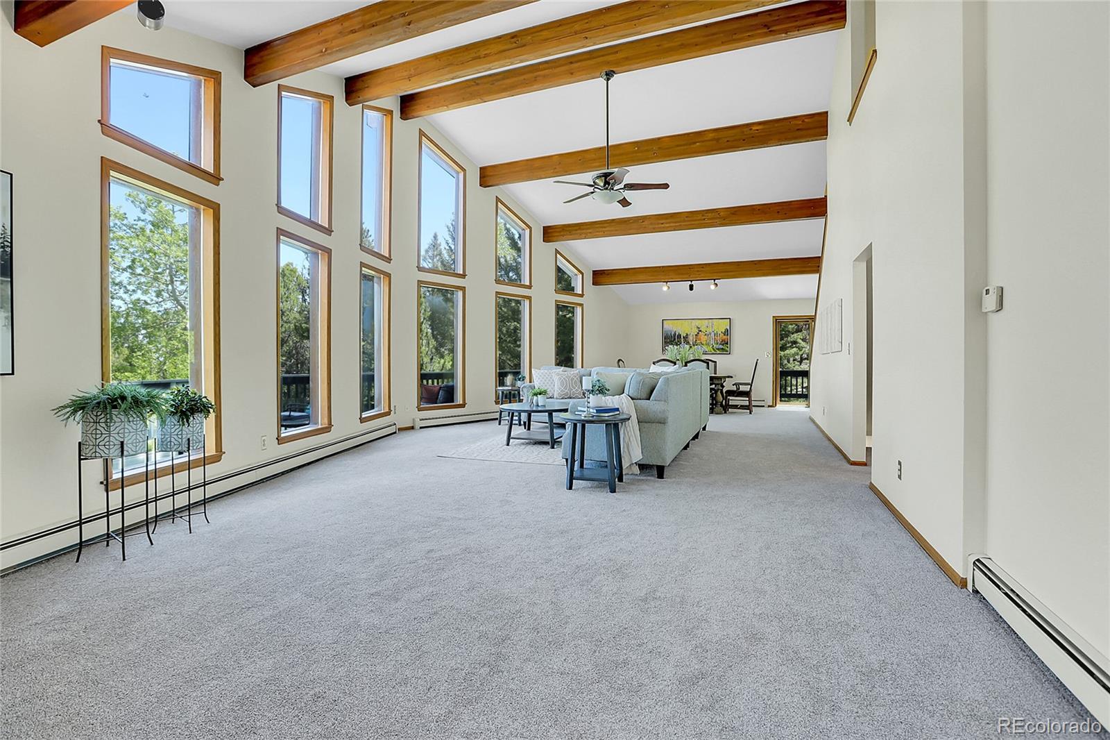 11333 Conifer Mountain Road Conifer, CO 80433 - Photo 11 of 50 a living room with furniture and large windows