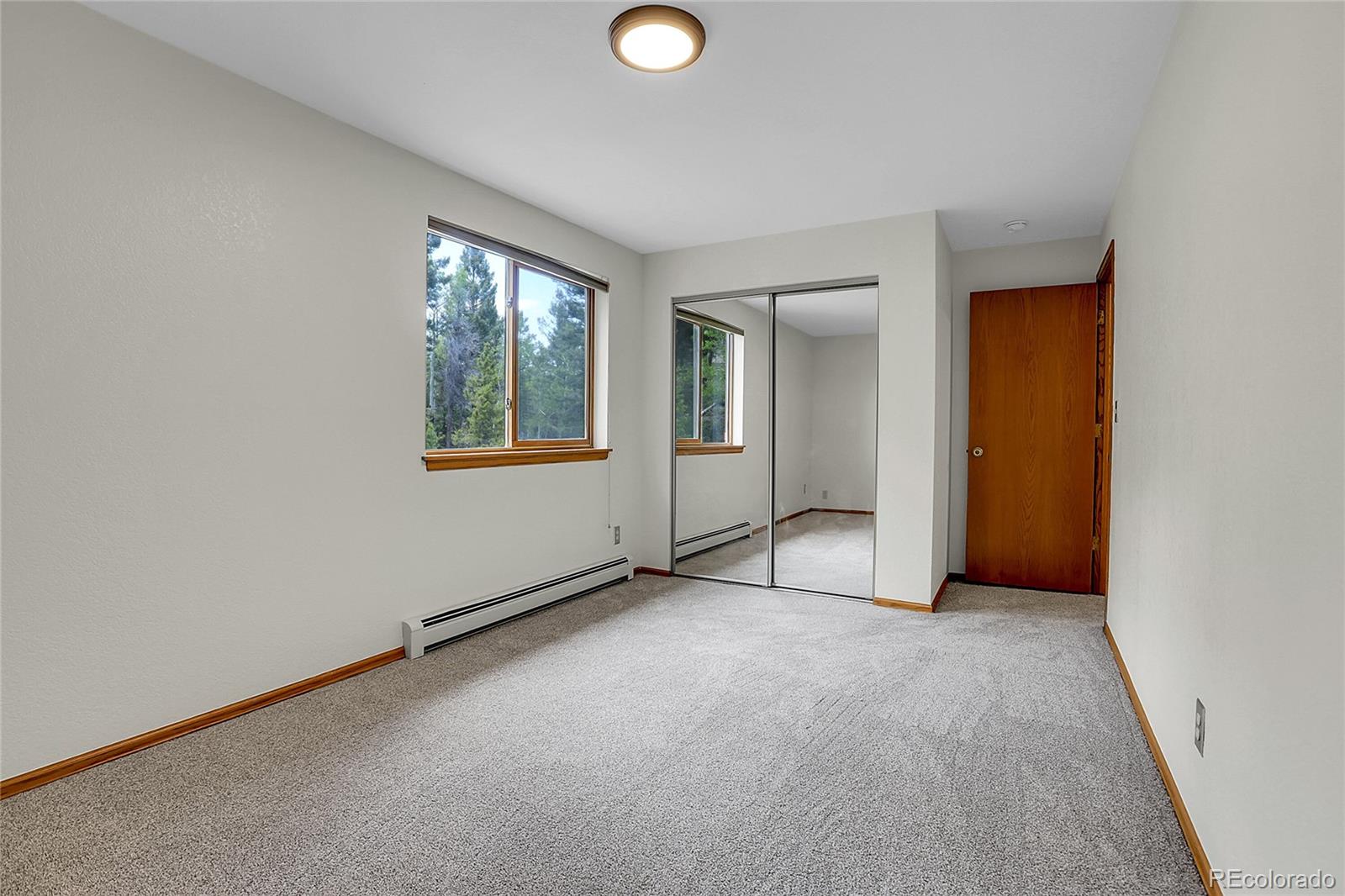 11333 Conifer Mountain Road Conifer, CO 80433 - Photo 32 of 50 an empty room with windows and mirror