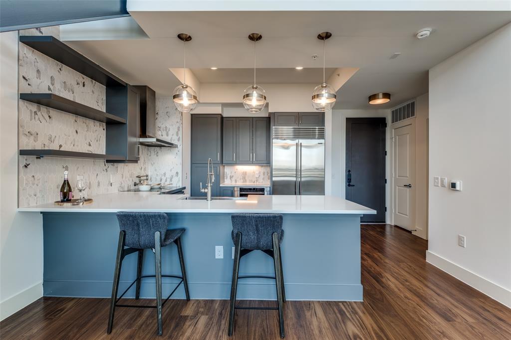 3611 Congress Avenue, Unit 2103 Dallas, TX 75219 - Photo 8 of 25 a kitchen with cabinets wooden floor and stainless steel appliances