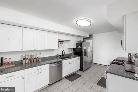 a kitchen with granite countertop a sink stainless steel appliances and cabinets