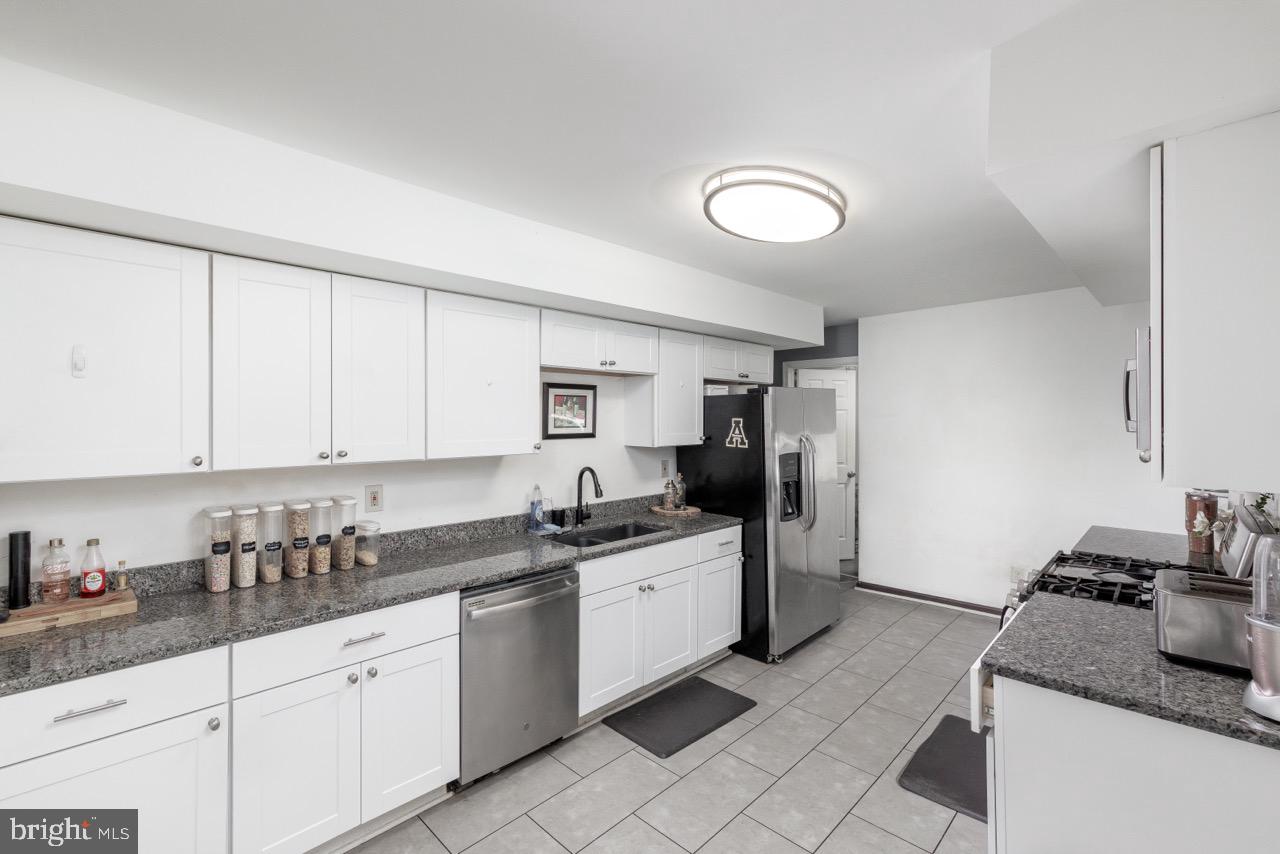 812 Silver Avenue Baltimore, MD 21221 - Photo 5 of 21 a kitchen with granite countertop a sink stainless steel appliances and cabinets