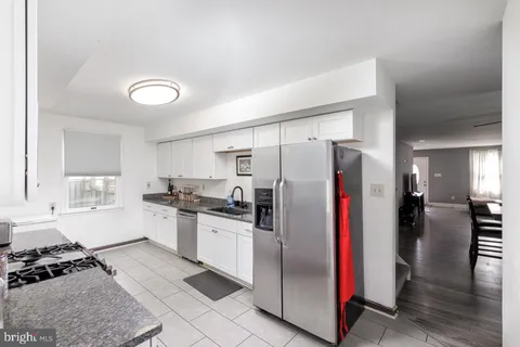 a kitchen with stainless steel appliances kitchen island granite countertop a refrigerator and a stove