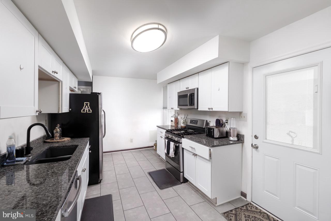 812 Silver Avenue Baltimore, MD 21221 - Photo 7 of 21 a kitchen with granite countertop a sink stove and refrigerator