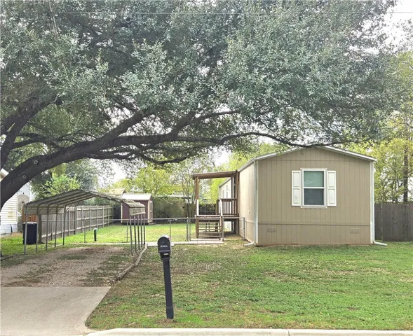 a view of backyard of house with green space