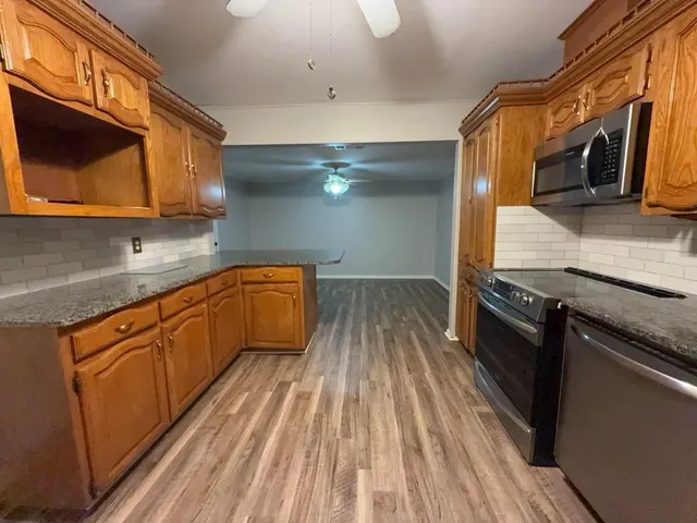 a kitchen with granite countertop stainless steel appliances and wooden cabinets