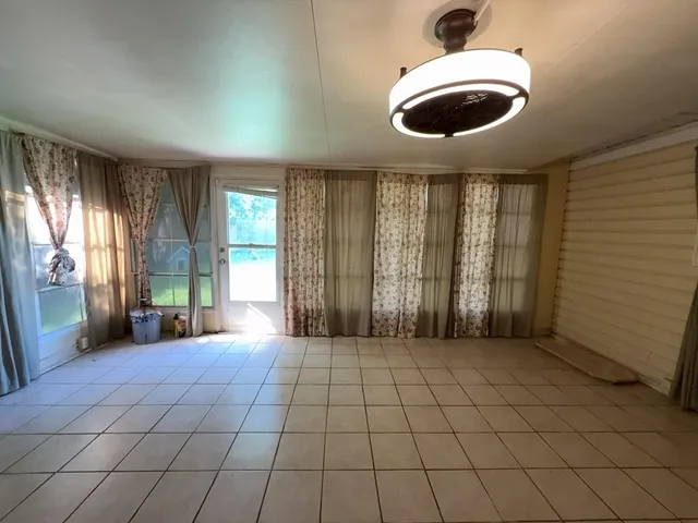 a view of a livingroom with an empty space and a window