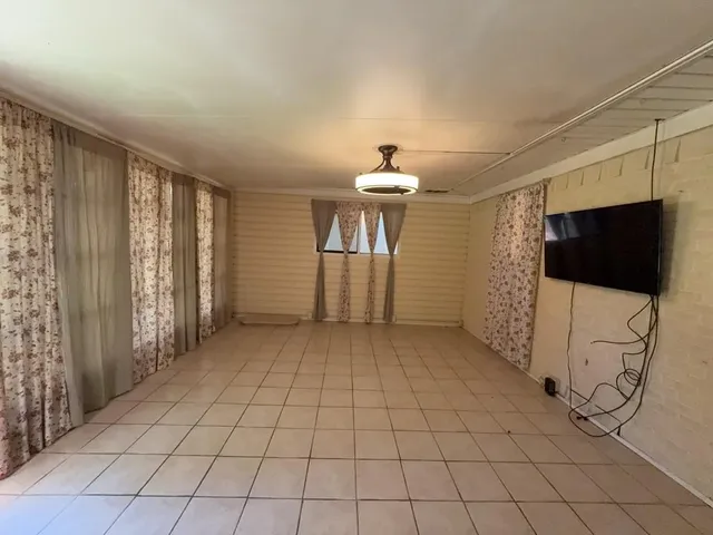 a brick house next to a yard with a large tree