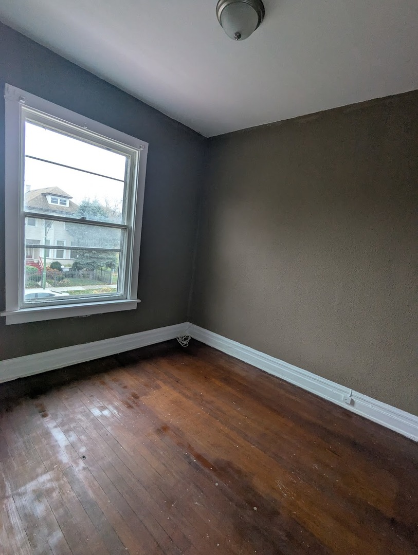 324 West 112th Street Chicago, IL 60628 - Photo 12 of 17 an empty room with wooden floor and windows